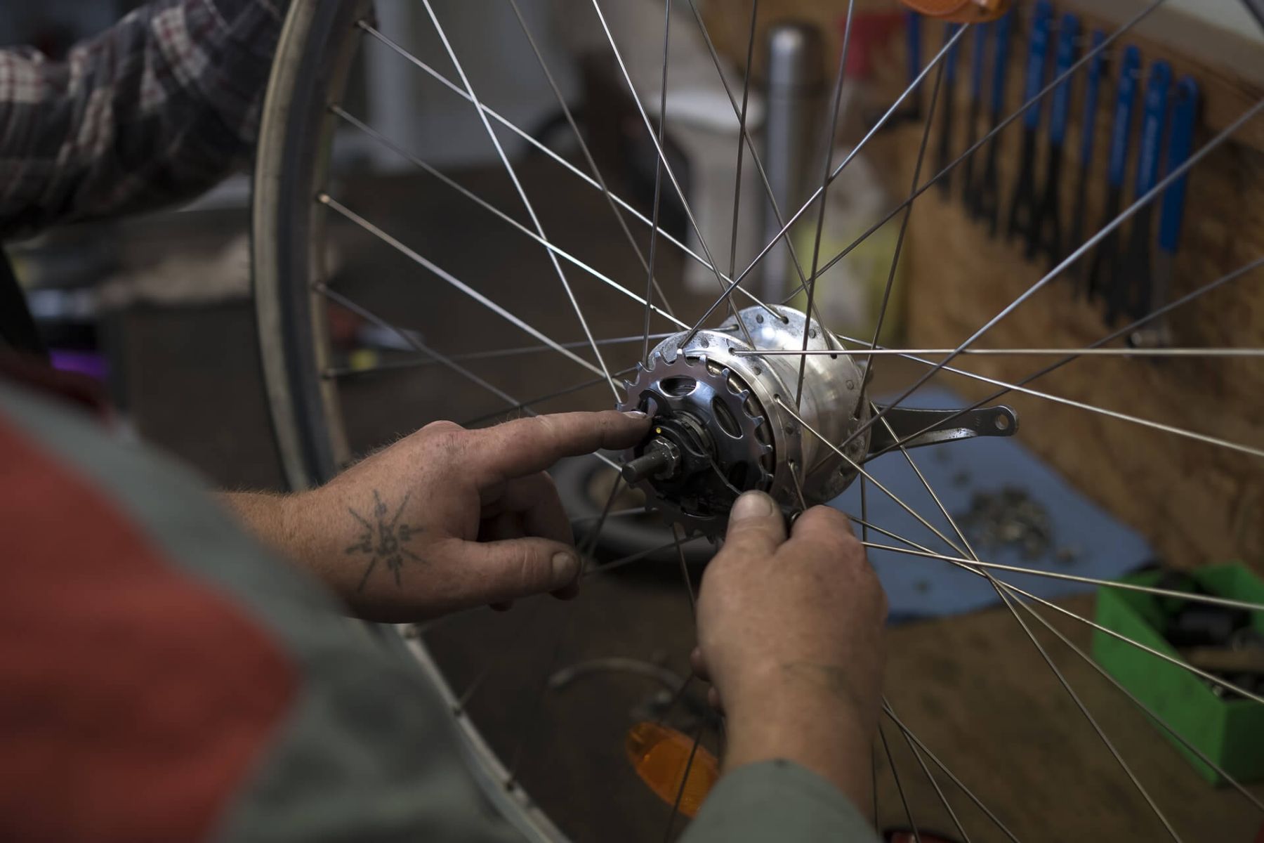 Zweiradmechatroniker untersucht ein Fahrrad auf Schäden.