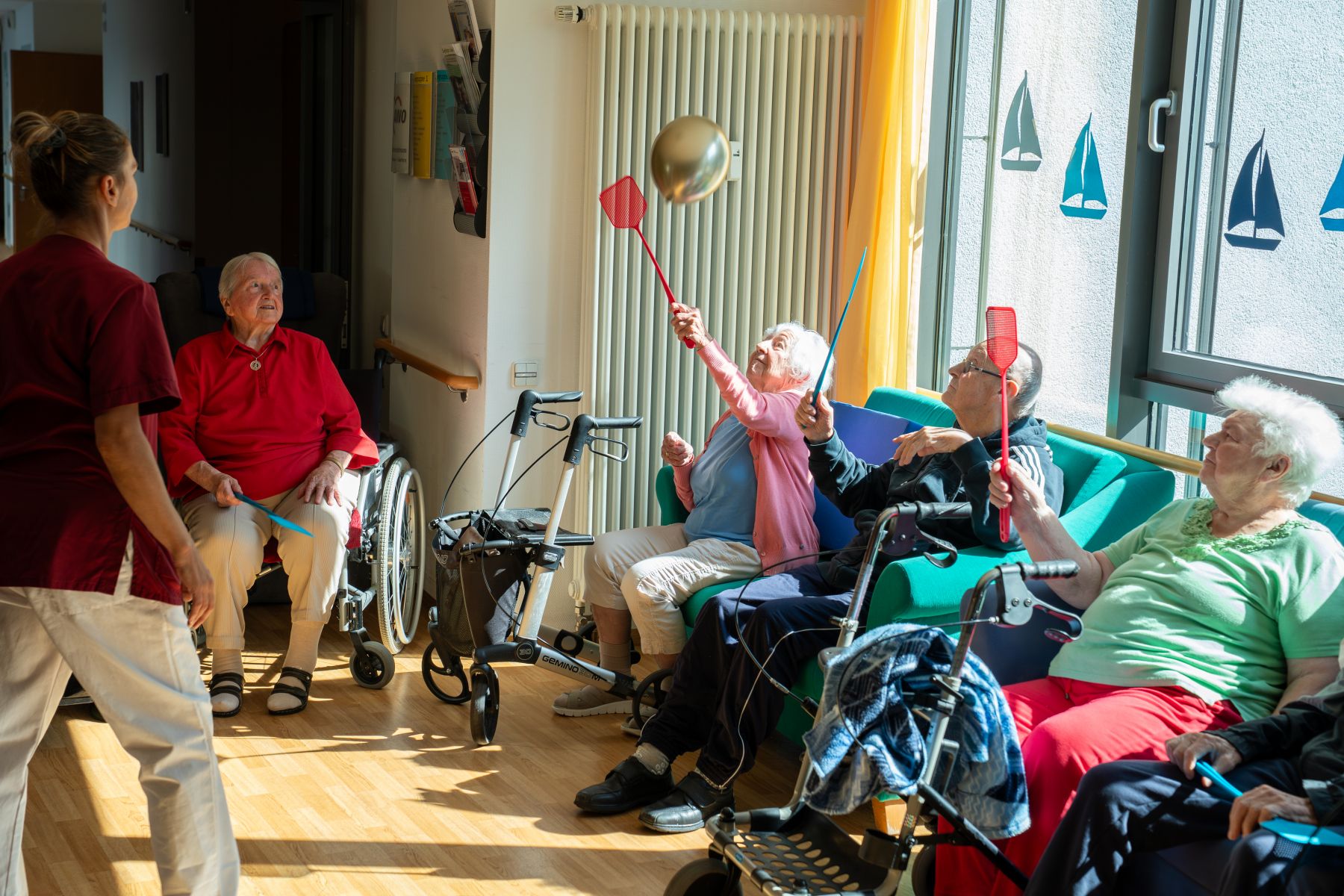 Senioren spielen alle gemeinsam mit dem Luftballoon